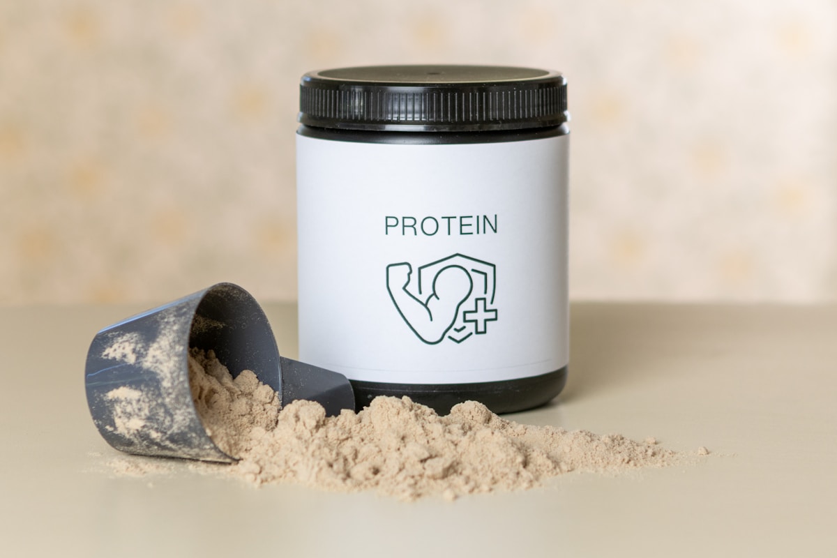 Tub of protein powder with a measuring scoop